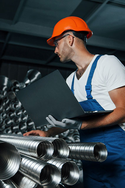 Vertical photo. Man in uniform works on the production. Industrial modern technology